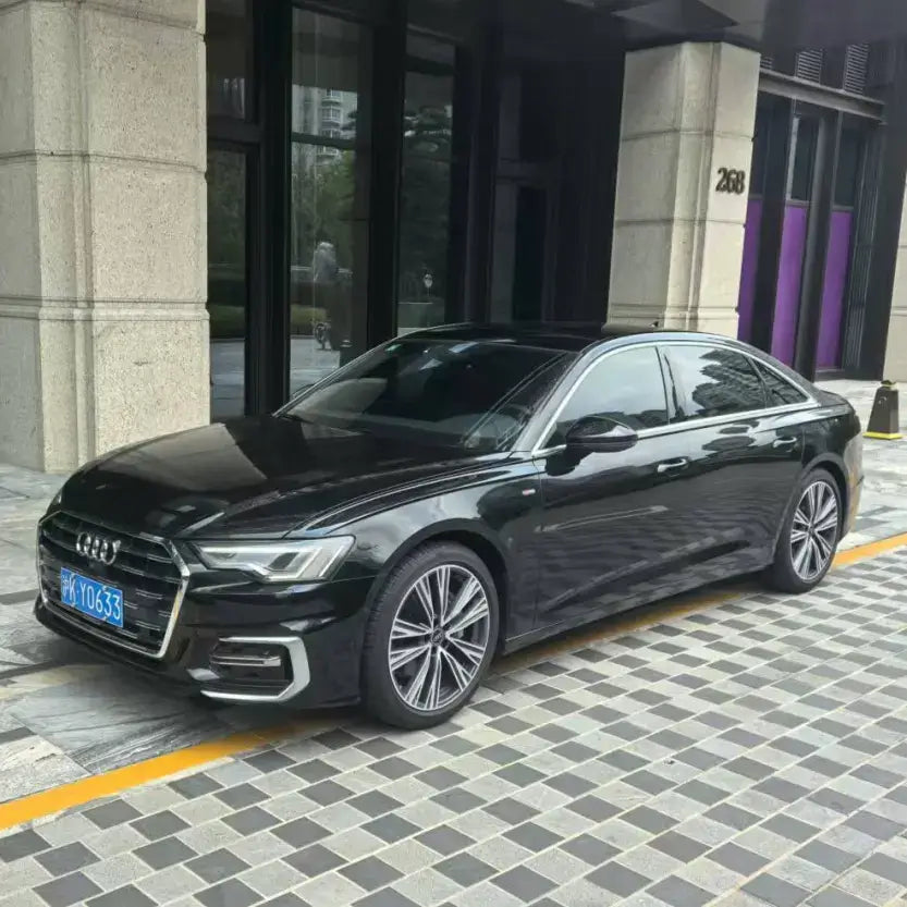 Black Audi A6 parked outside a building for the Shanghai Private Car & Van Service (City Only).