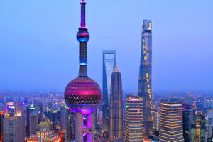 Aerial drone view of the Oriental Pearl Tower and Shanghai Tower rising above the Lujiazui skyline in Shanghai