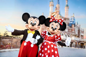 Mickey Mouse and Minnie Mouse posing in front of the Enchanted Storybook Castle at Shanghai Disneyland