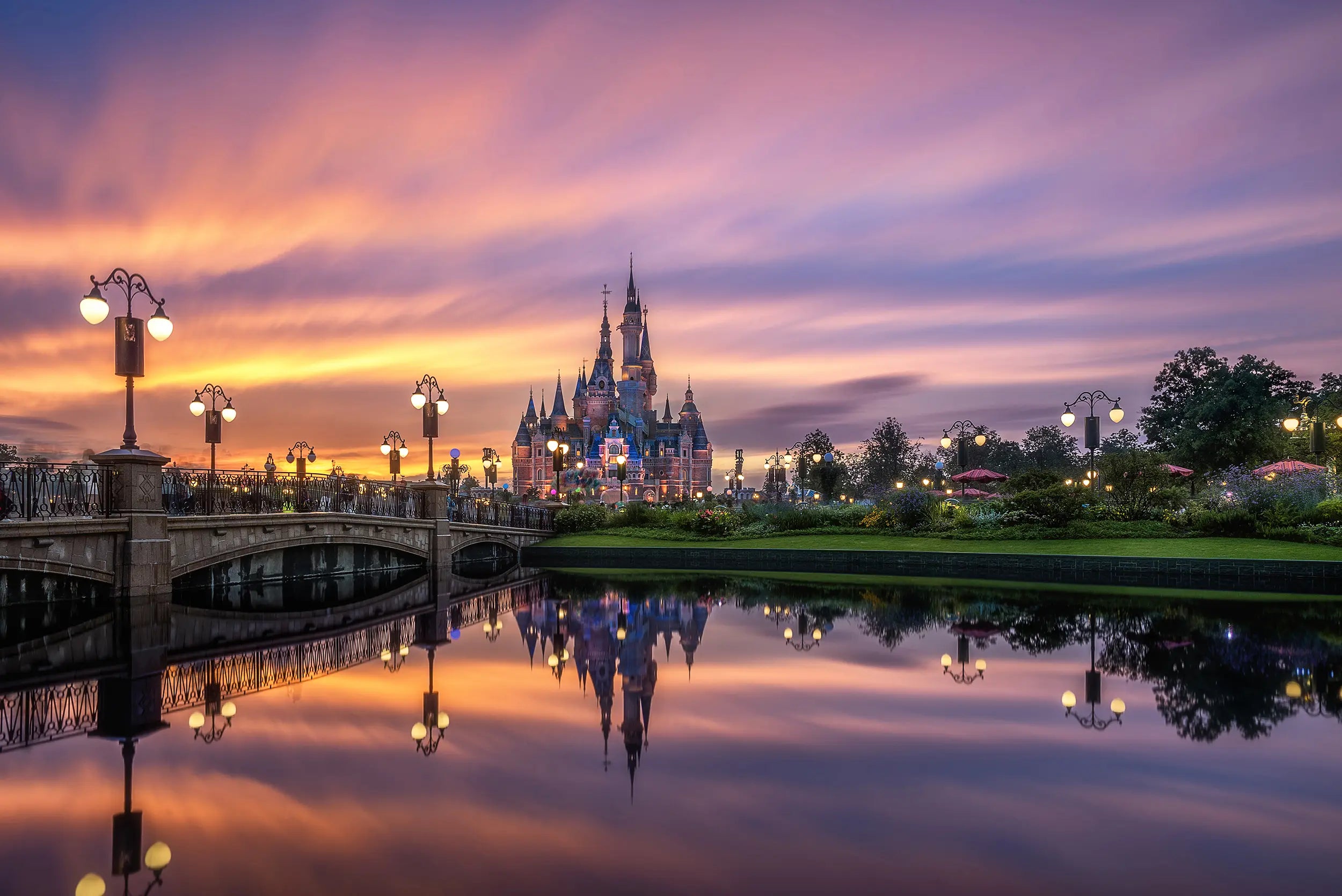 Enchanted Storybook Castle at dusk with a bridge and river at Shanghai Disneyland