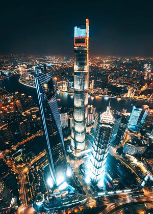 Aerial night view of Shanghai Tower and surrounding skyscrapers illuminated in the Lujiazui Financial District