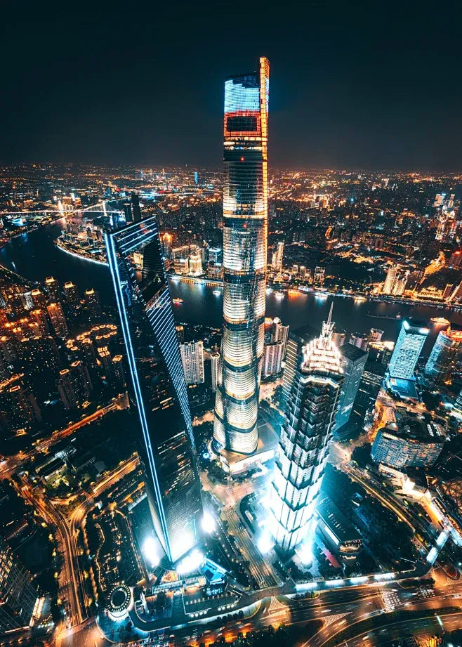 Aerial night view of Shanghai Tower and surrounding skyscrapers illuminated in the Lujiazui Financial District