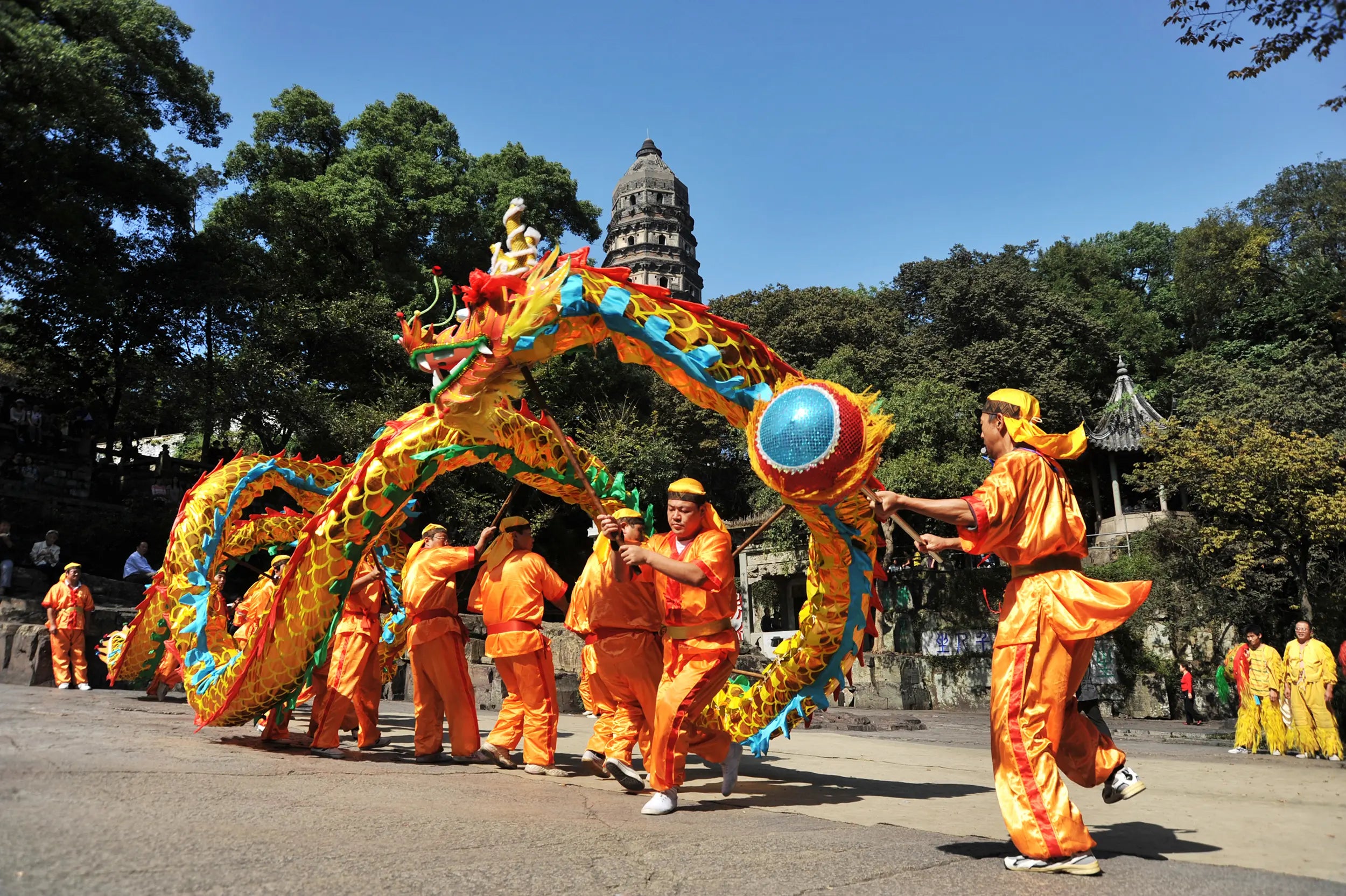 Traditional lion dance performance in front of the leaning Tiger Hill Pagoda in Suzhou, China