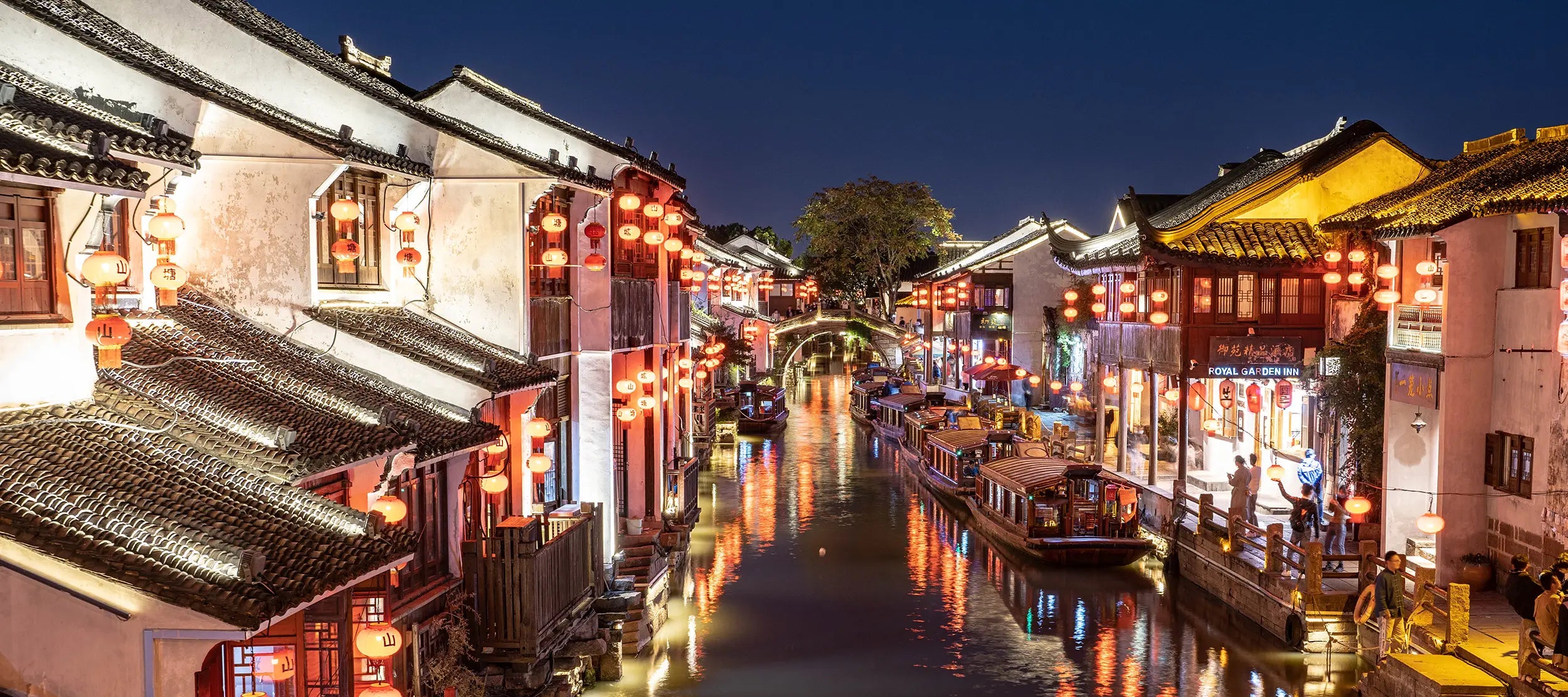 Traditional Chinese-style commercial buildings lining the small river near the Tiger Hill Scenic Area in Suzhou