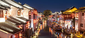 Traditional Chinese-style commercial buildings lining the small river near the Tiger Hill Scenic Area in Suzhou