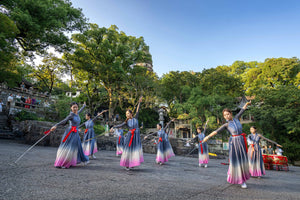 Group of women performing traditional Chinese sword dance in historical costumes inside Tiger Hill Scenic Area