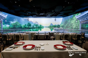 Chinese pavilion and flowing rivers projected on a large screen, with dining table arranged and prepared for guests at The Bund, Shanghai.