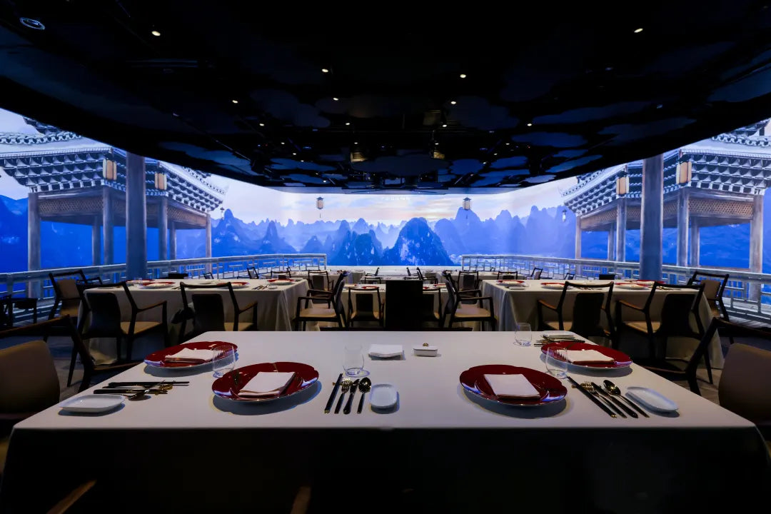 Immersive Chinese pavilion and landscape projected on a large screen, with neatly set dining table ready for guests at The Bund, Shanghai.