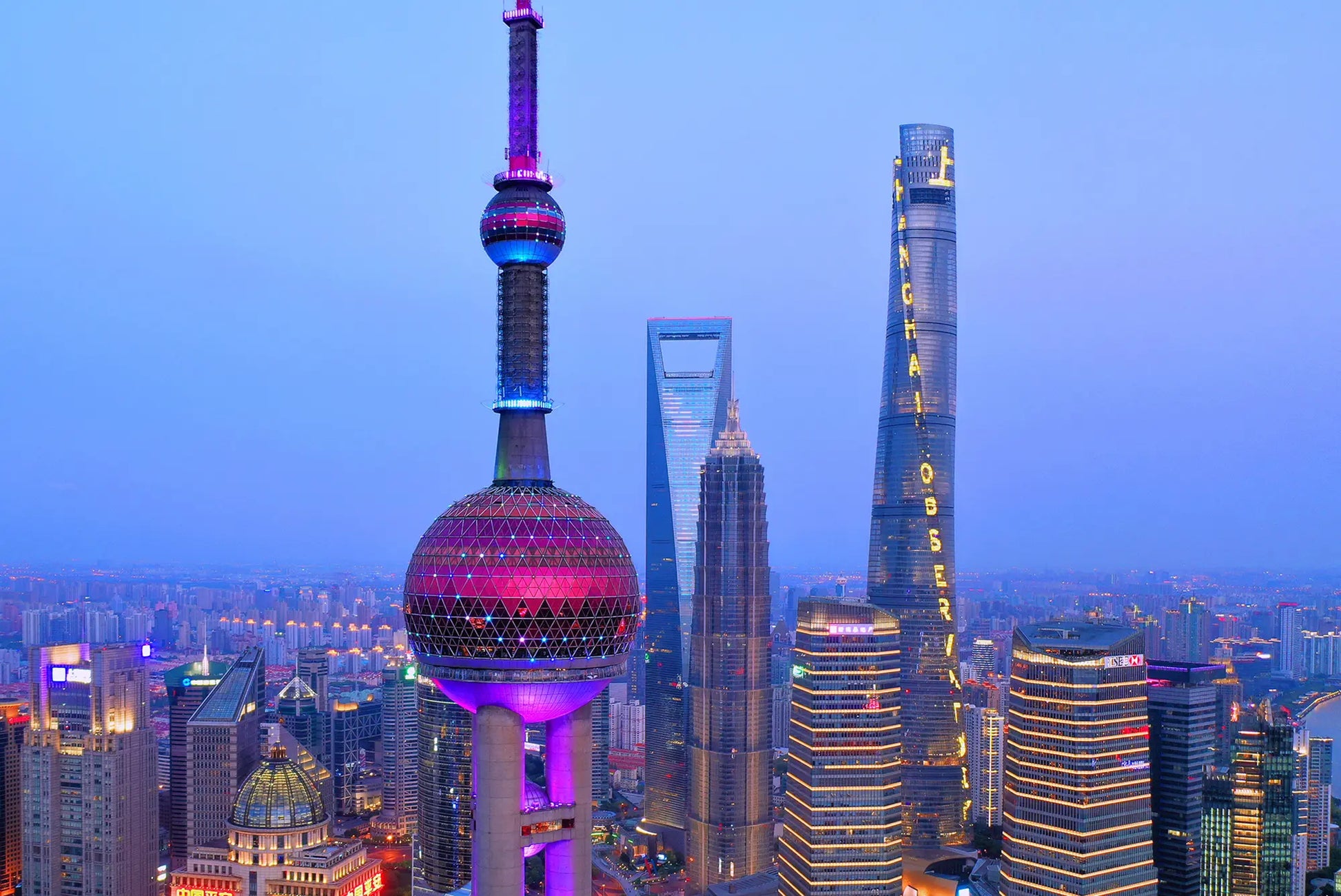 Aerial drone view of the Oriental Pearl Tower and Shanghai Tower rising above the Lujiazui skyline in Shanghai
