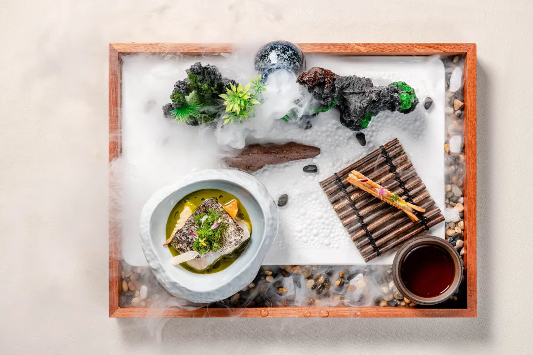 A fish dish served with tea, miniature rockery, and mist effects, creating an artistic presentation at The Bund, Shanghai.