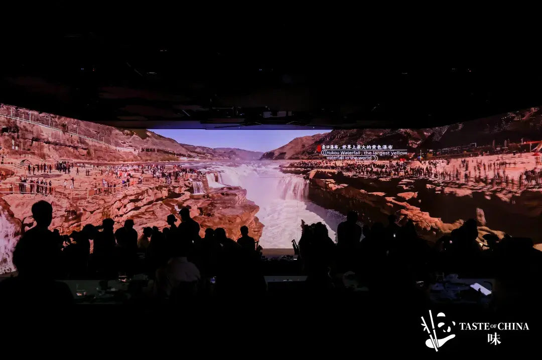 Guests dining with a projection of Hukou Waterfall, the world’s largest Yellow River waterfall, in the background at The Bund, Shanghai.