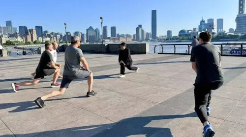 Kung Fu master and students practicing leg stretching exercises during class.