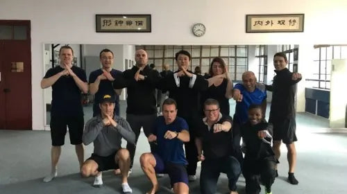 Kung Fu master posing for a group photo with international students after martial arts class in Shanghai.