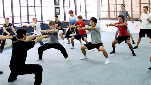 Students practicing the horse stance under the guidance of a Kung Fu master in Shanghai.