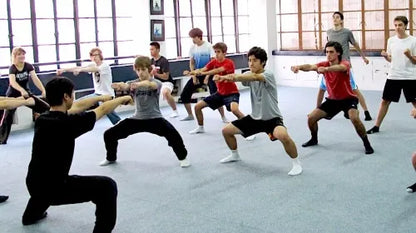 Students practicing the horse stance under the guidance of a Kung Fu master in Shanghai.
