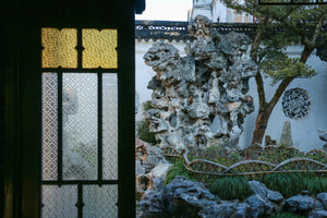 Rockery of Taihu stones with bamboo fence and moon window in Suzhou’s Lion Grove Garden, capturing the peaceful charm of classical Chinese landscaping.