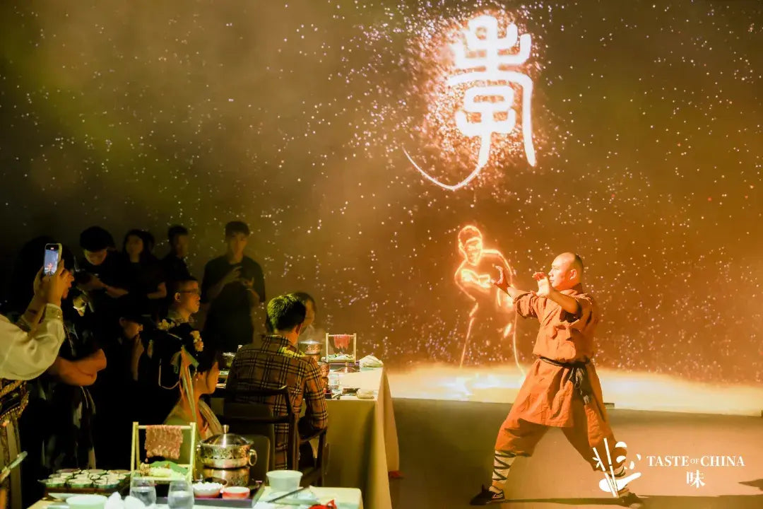 A Shaolin monk performing Dragon Claw hand techniques while guests dine and take photos at The Bund, Shanghai.